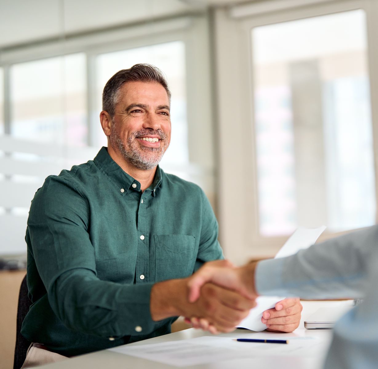 Smiling middle aged business man shaking hands with his advisor